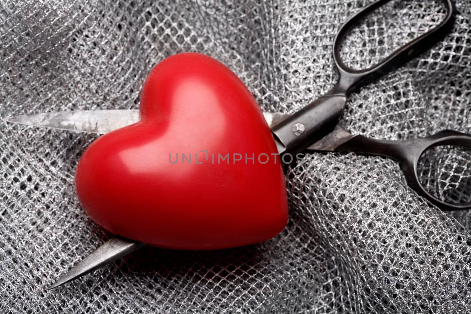 Close-up of a heart and a pair of scissors on fabric