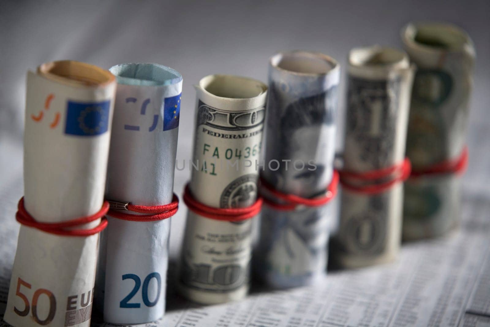 Close-up of paper currency rolls with rubber bands in a row