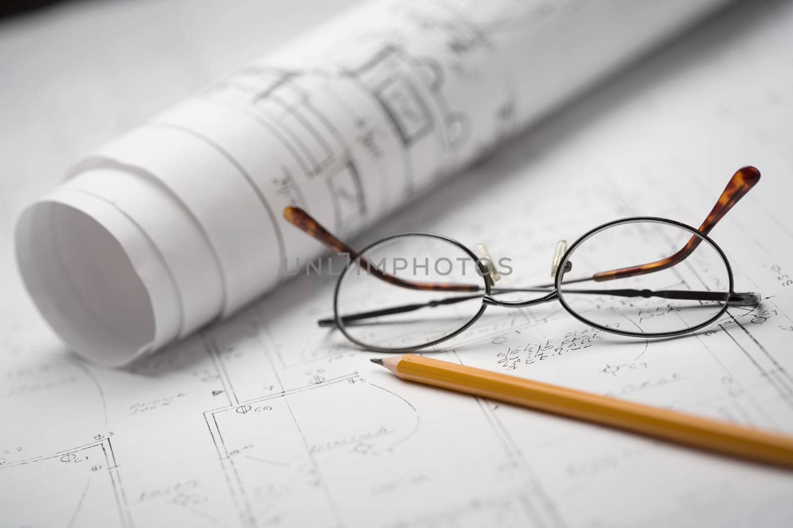 Close-up of a pencil and eyeglasses on a sheet of paper