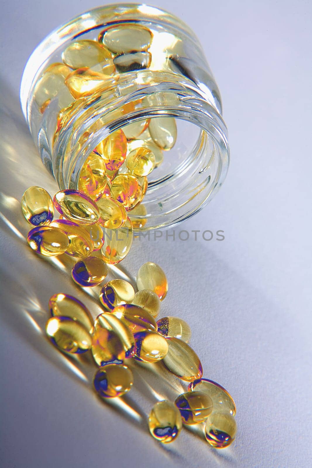 Close-up of vitamin e capsules spilling from a jar
