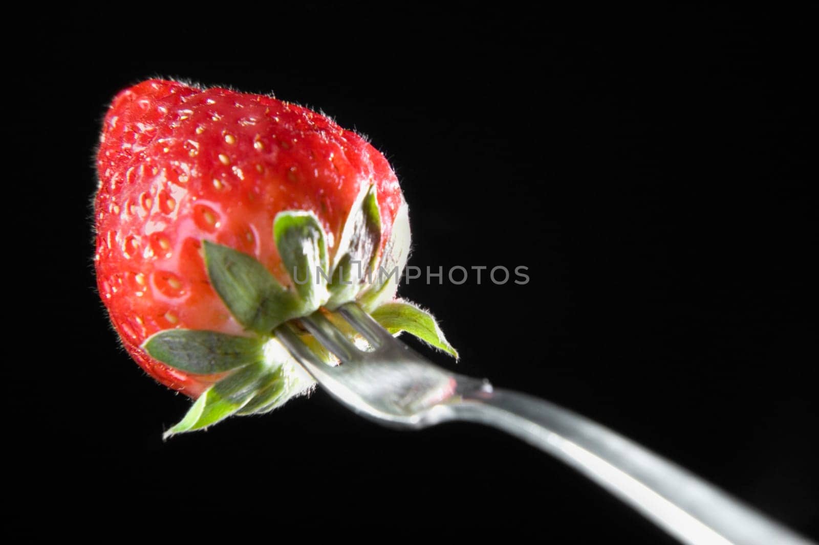 Close-up of a fork with a strawberry
