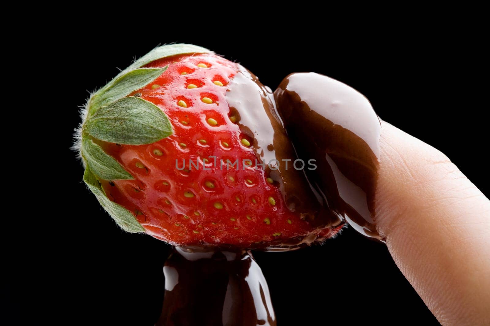 Close-up of a personŽs hand holding a chocolate covered strawberry