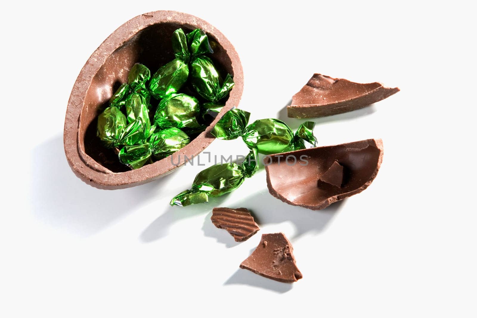 High angle view of broken chocolate egg with sweets