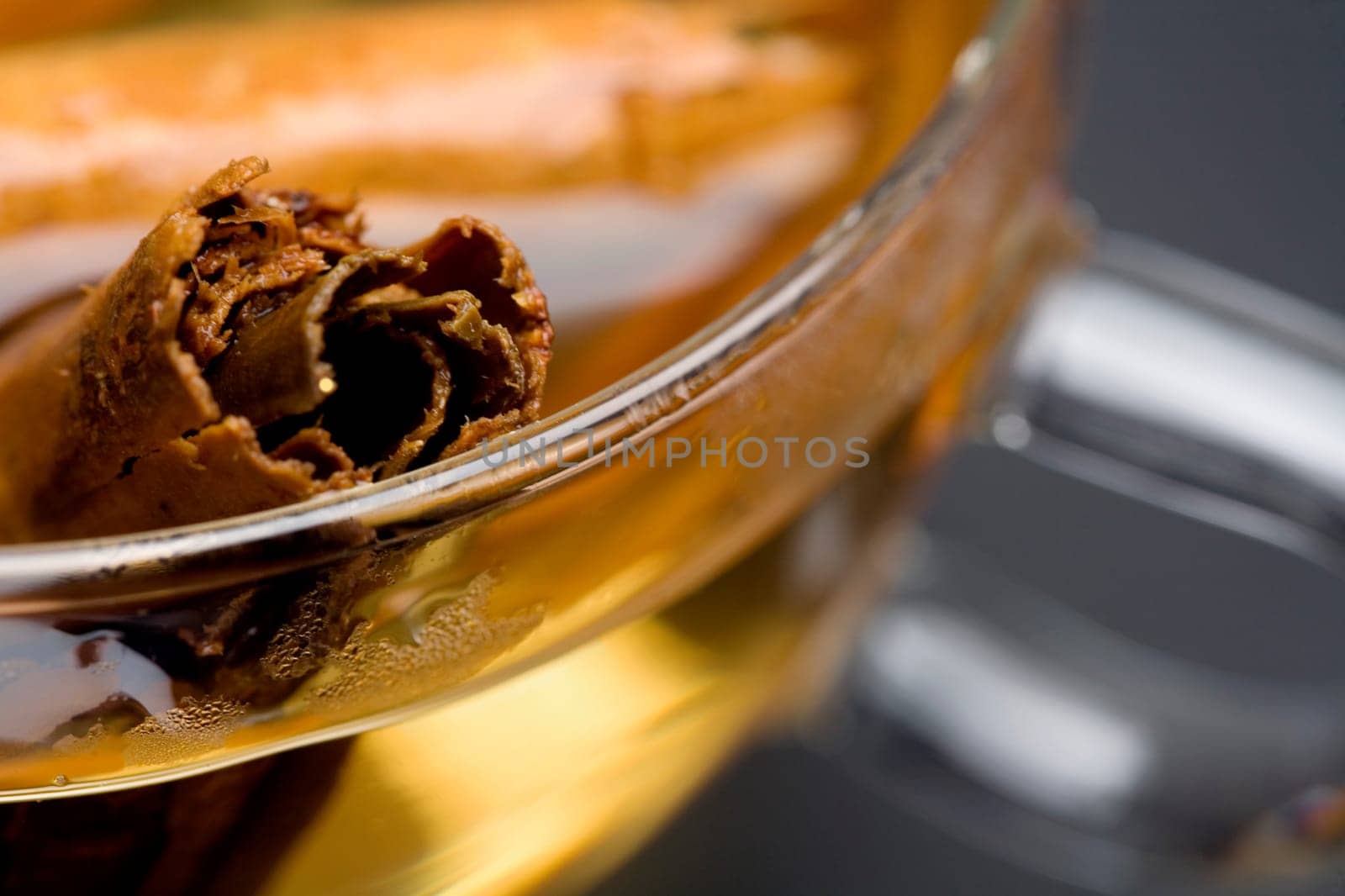 Close-up of a cinnamon stick in a bowl of cider