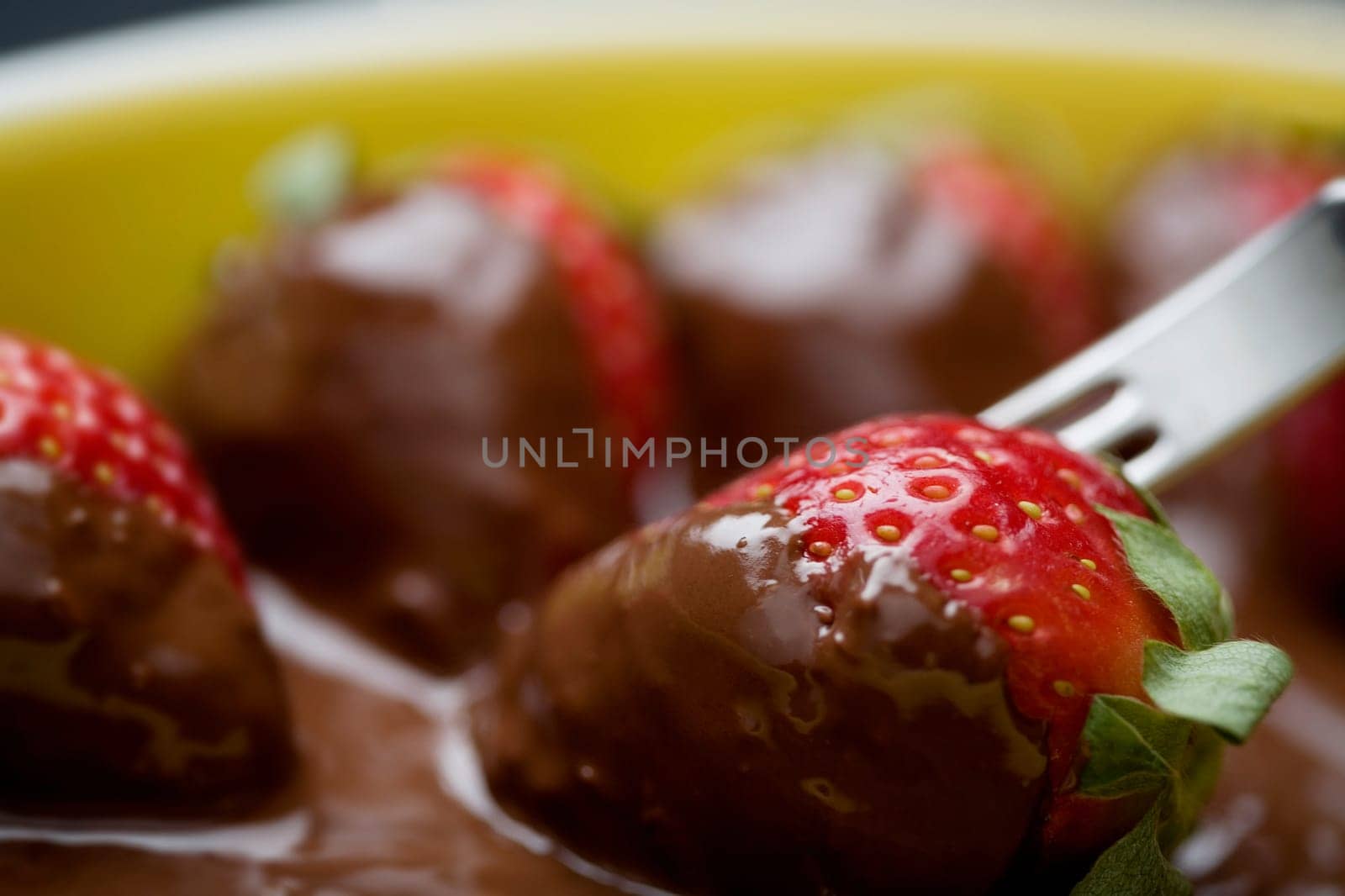 Close-up of a fork with chocolate covered strawberries