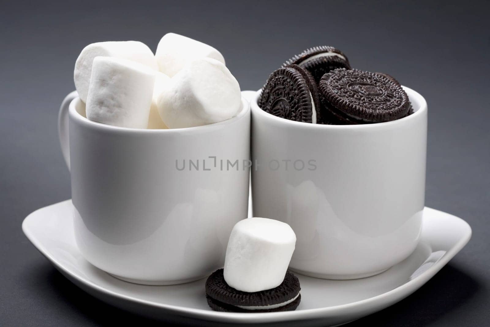Close-up of cookies and marshmallows in two cup