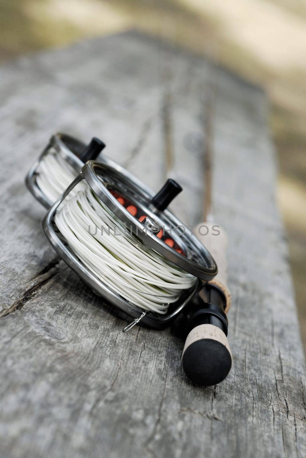 Close-up of two fishing reels and a fishing rod