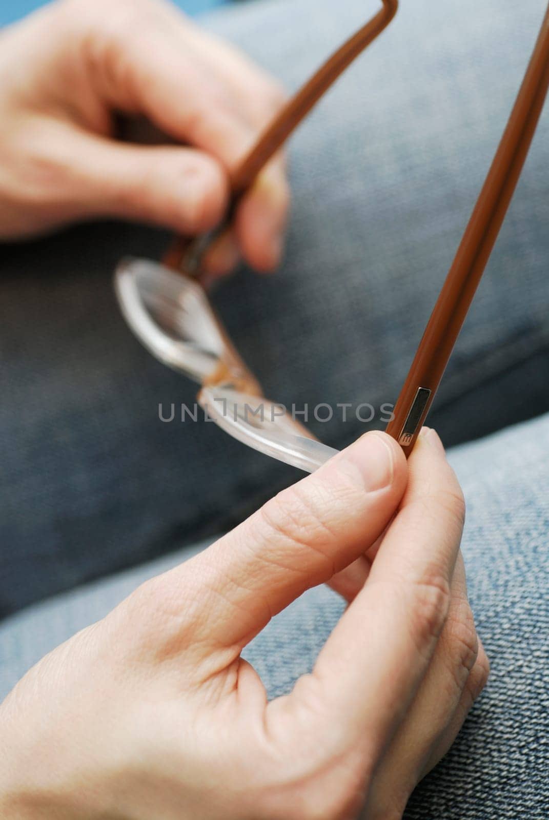 Close-up of a personŽs hands holding a pair of eyeglasses