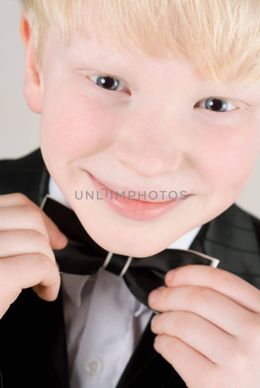 Portrait of a boy holding his bow tie