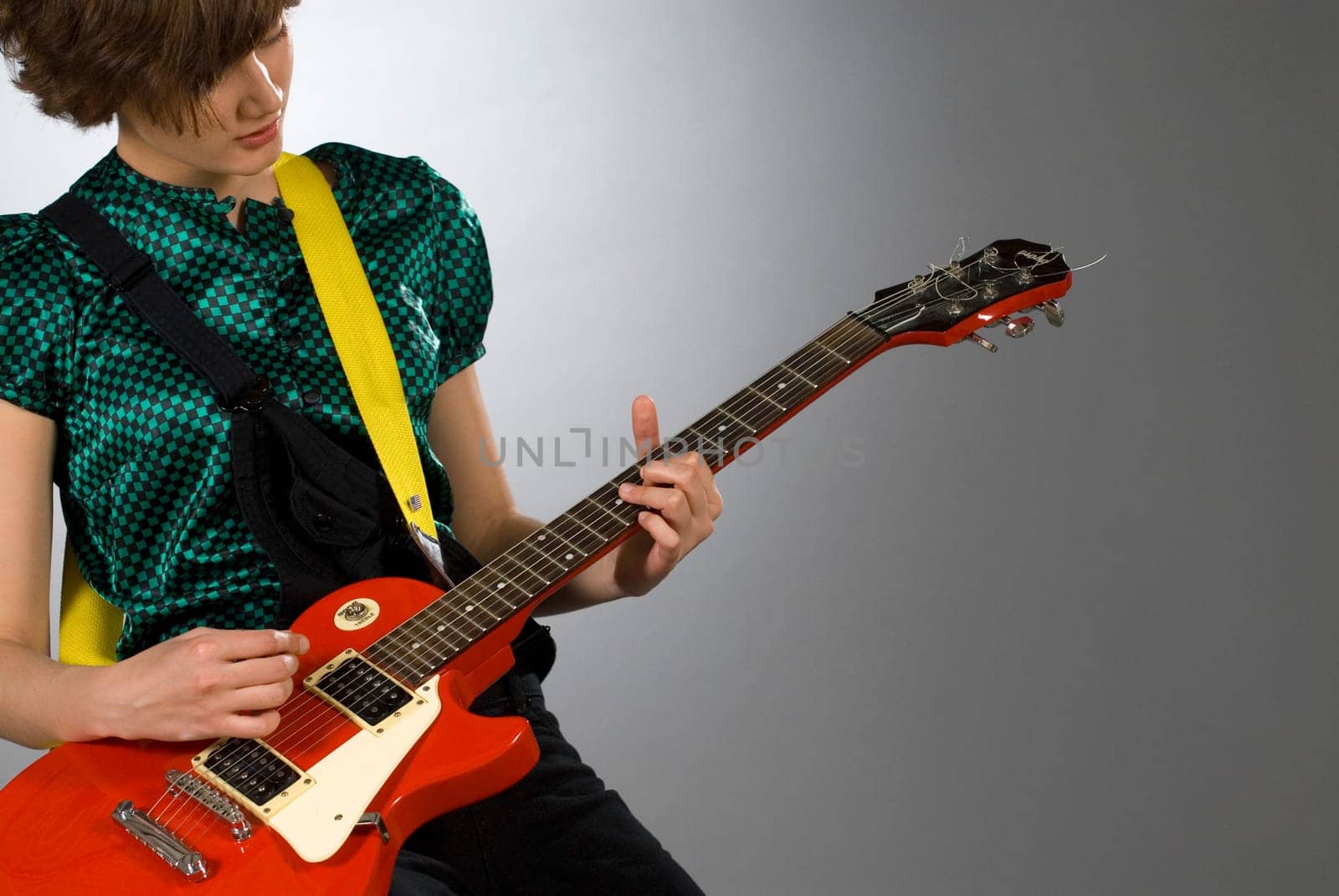 Close-up of a female guitarist playing a guitar