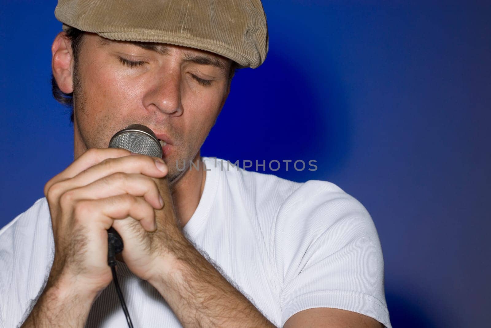 Close-up of a young man singing into a microphone