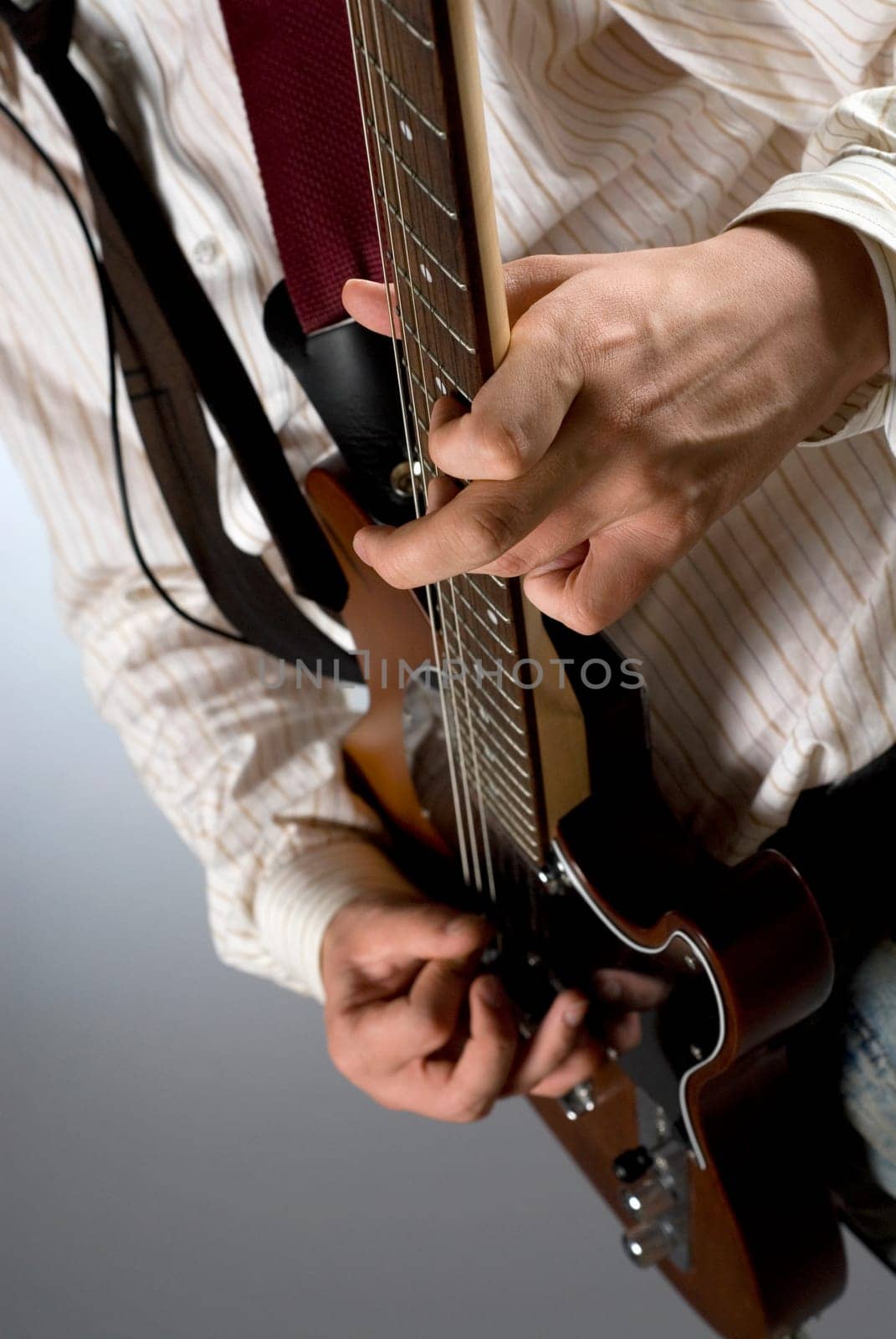 Mid section view of a male guitarist playing a guitar