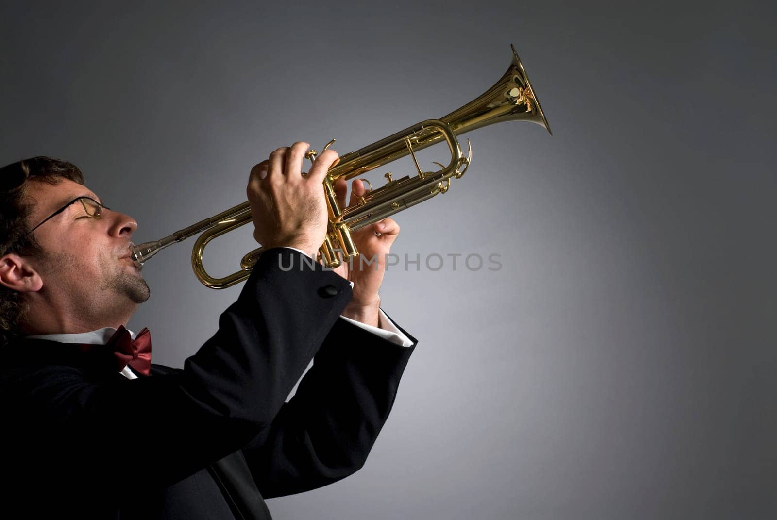 Side profile of a musician playing a trumpet