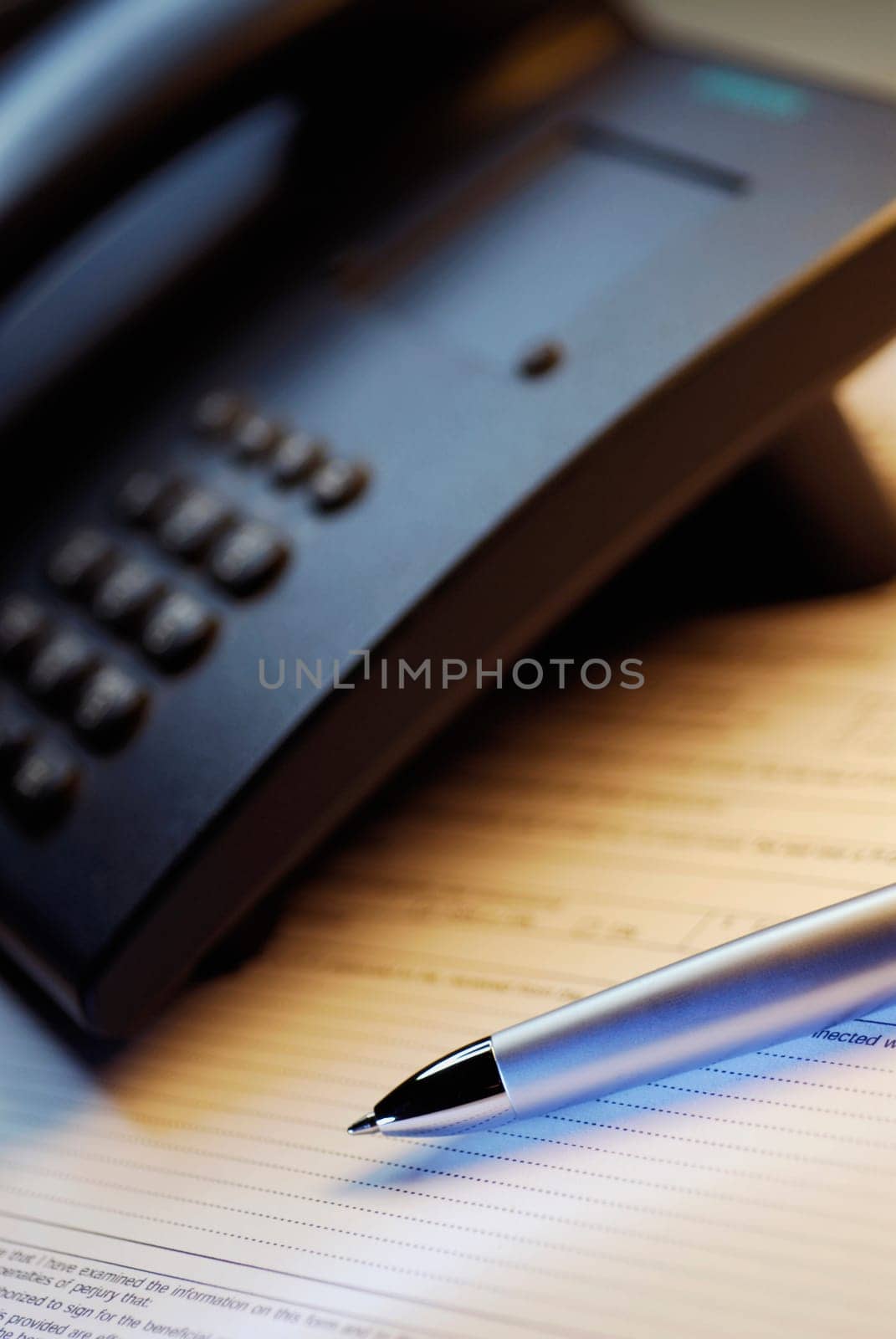 Close-up of a telephone and a pen on a form