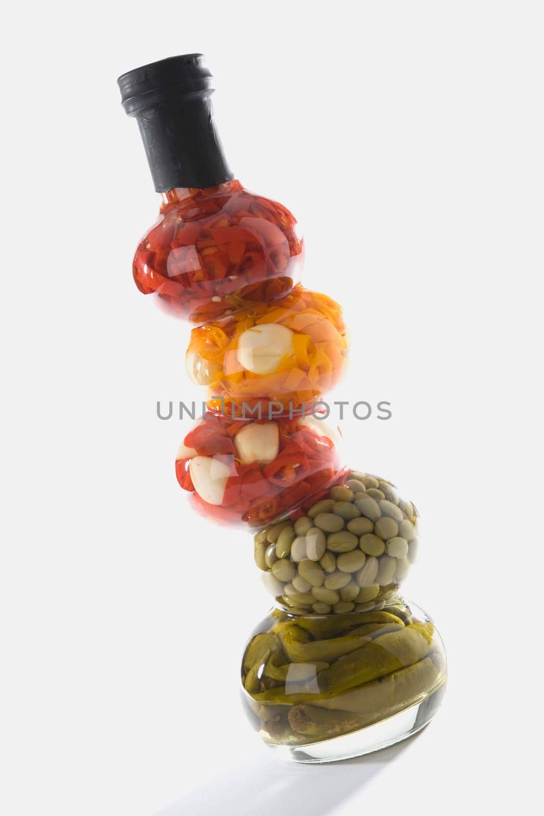 Close-up of chopped bell peppers and beans in a glass bottle
