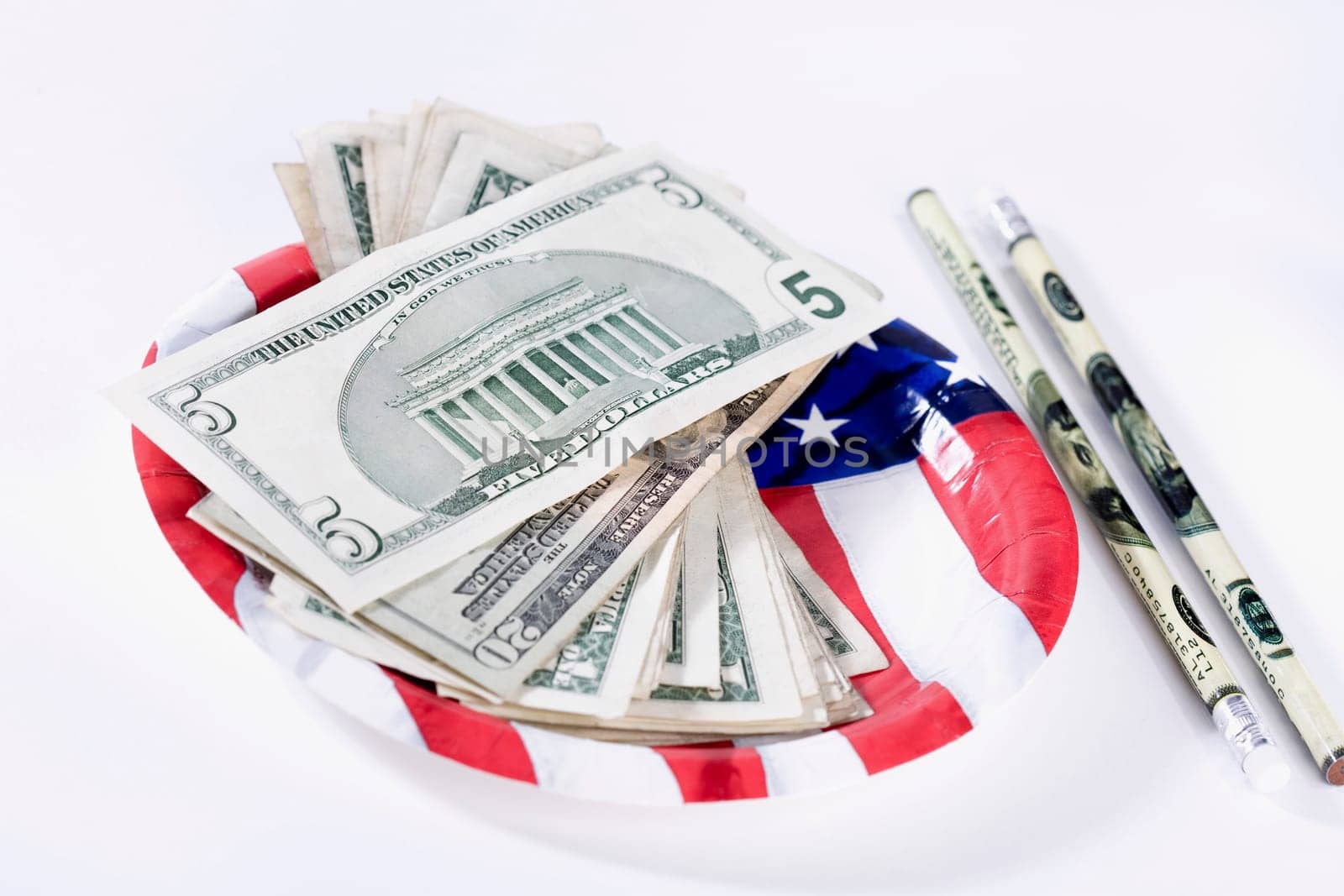 US dollar bills with an American flag and pencils