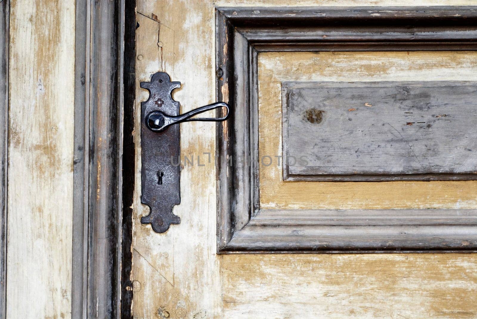 Close-up of a door handle on a wooden door