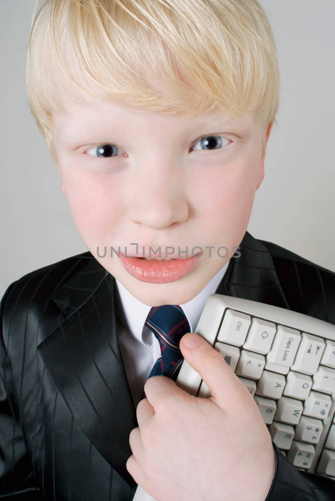 Close_up of a boy holding a computer keyboard