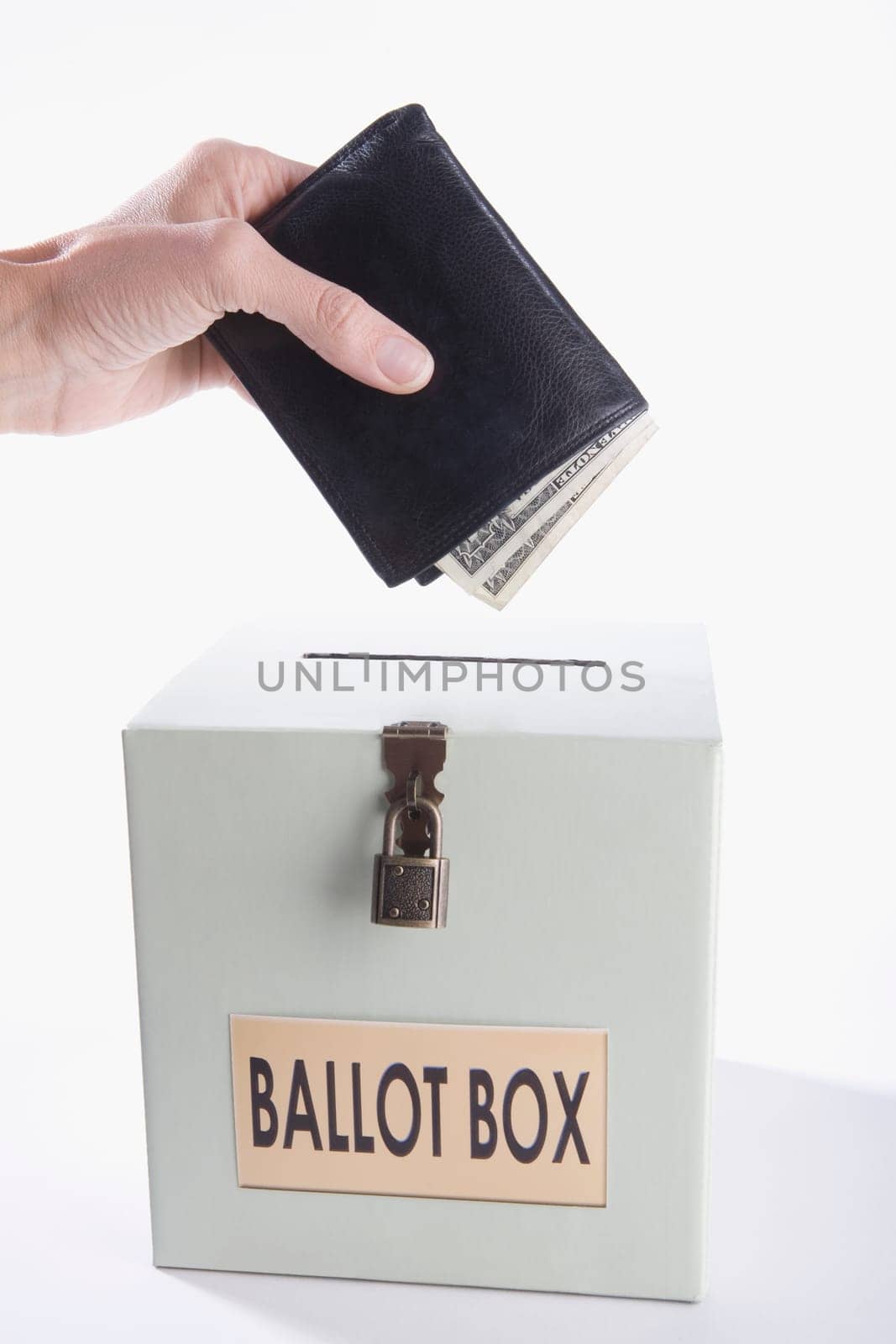 Close_up of a personŽs hand putting money full of wallet into a ballot box
