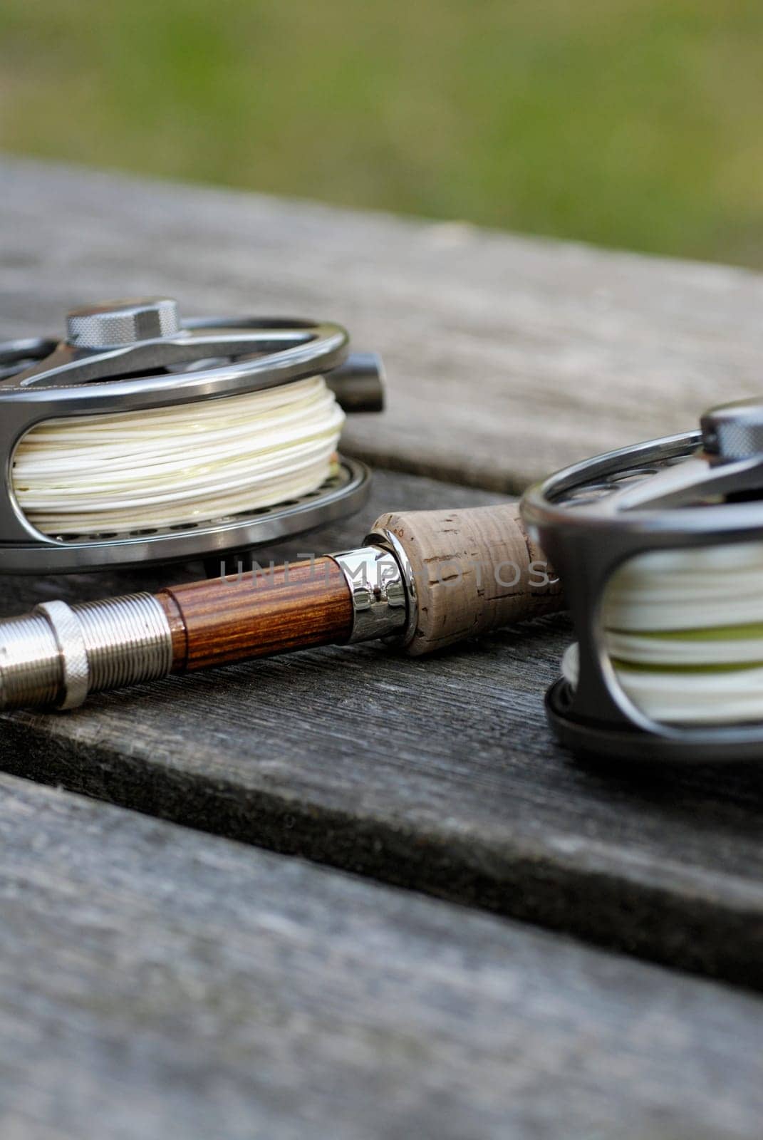 Close-up of two fishing reels and a fishing rod