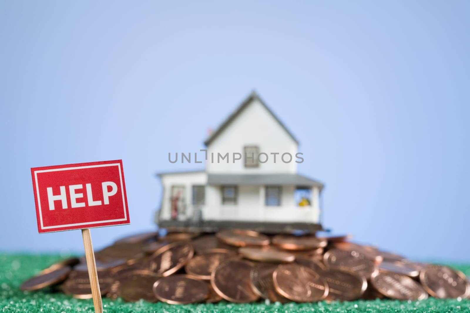 Help sign board in front of a model home on a pile of coins