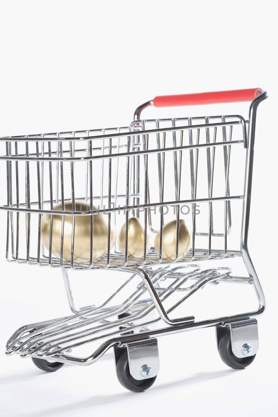 Close_up of three golden eggs in a shopping cart