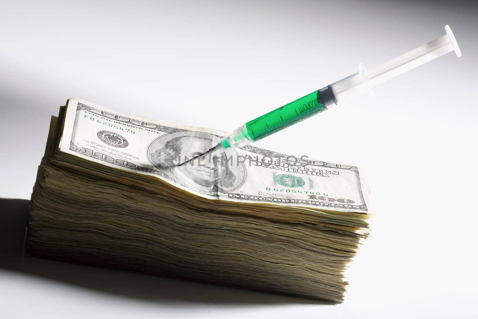 Close_up of a syringe on US paper currency