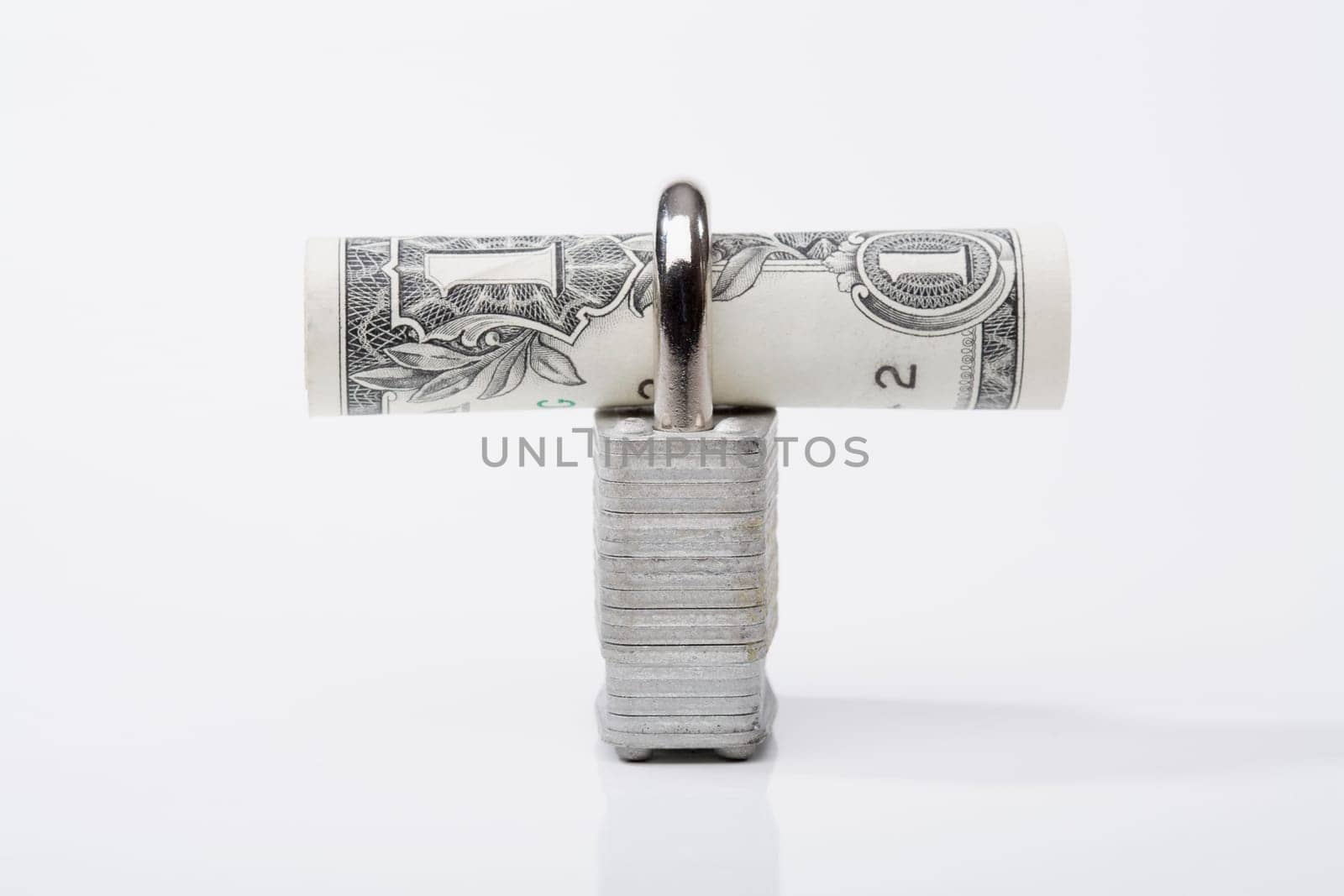 Close_up of a rolled bank note with a padlock