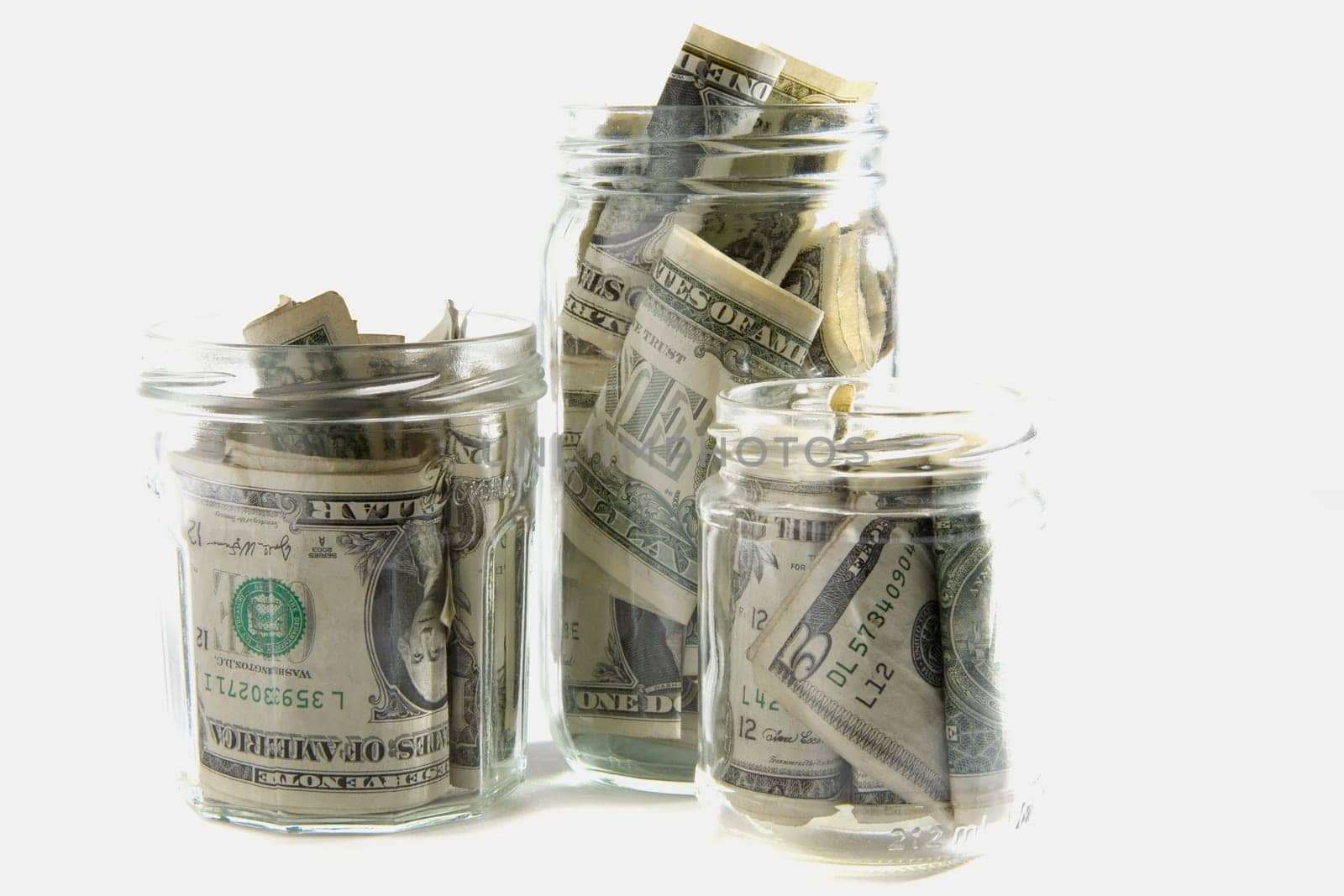 Dollar bills squashed into three jars