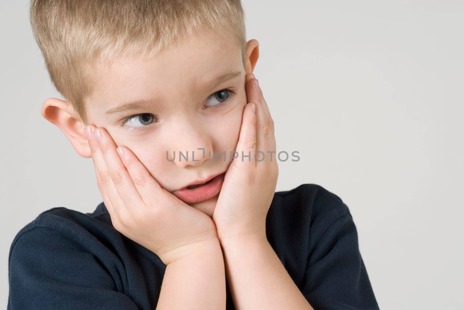 Close_up of a boy thinking with his head in his hands