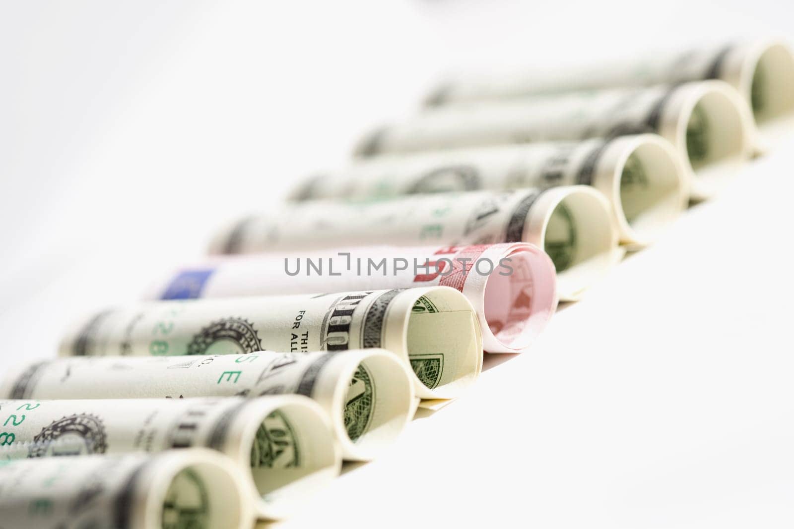 Rolls of US paper currency with European union euro note