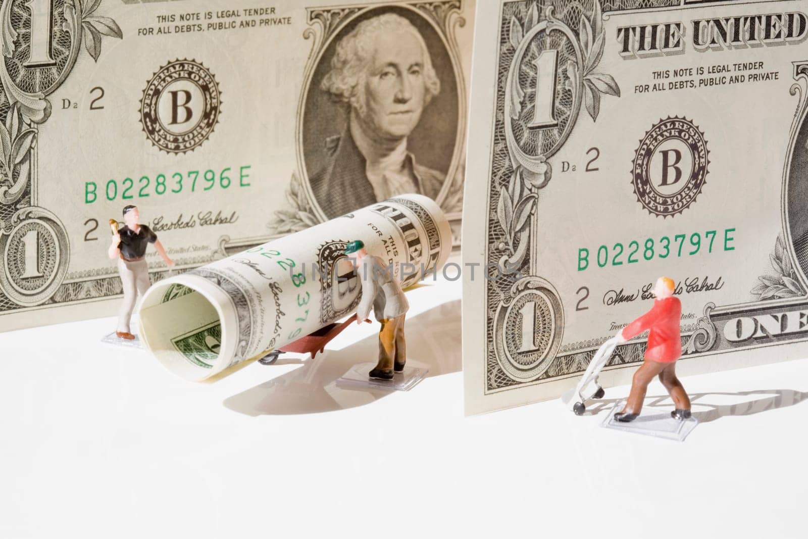 Figurines of manual workers with US dollar bills