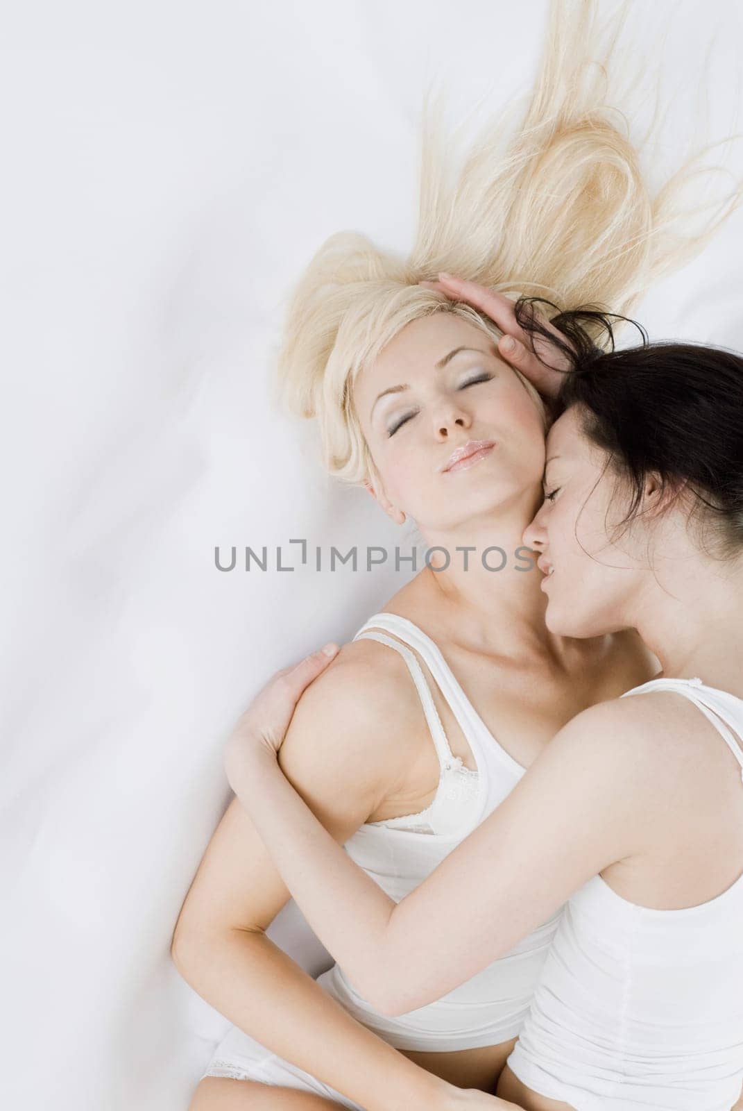 Female homosexual couple embracing each other on the bed