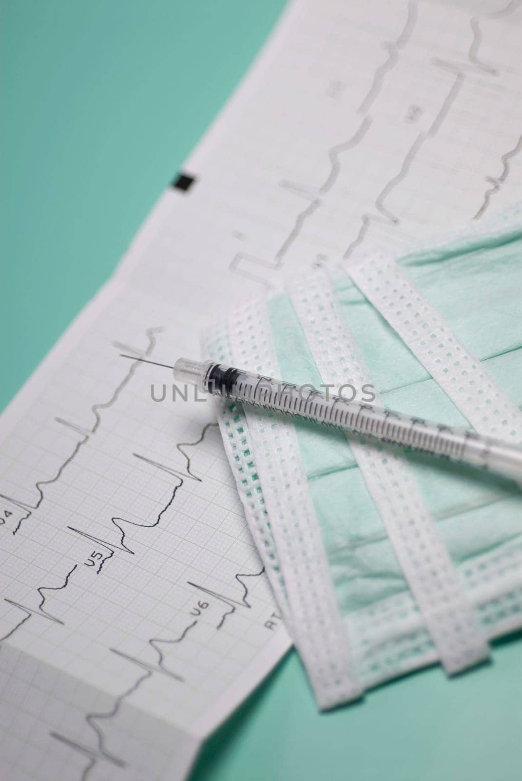 Close_up of a syringe on an electrocardiogram report