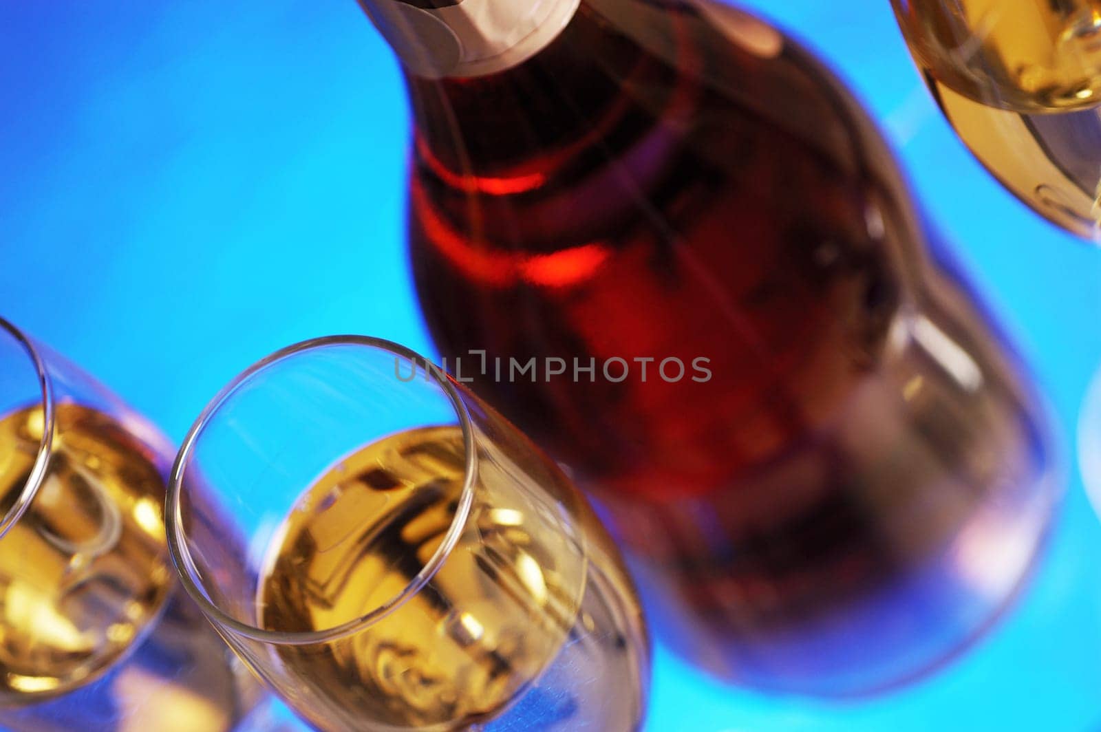 Close-up of a wine bottle with champagne in three champagne flutes