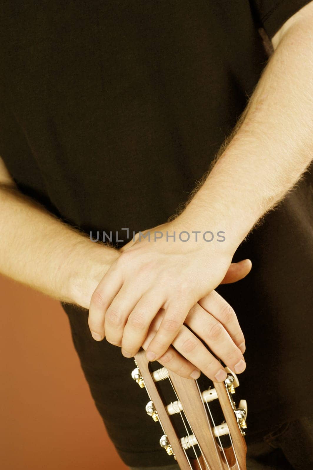 Mid section view of a musician holding an acoustic guitar