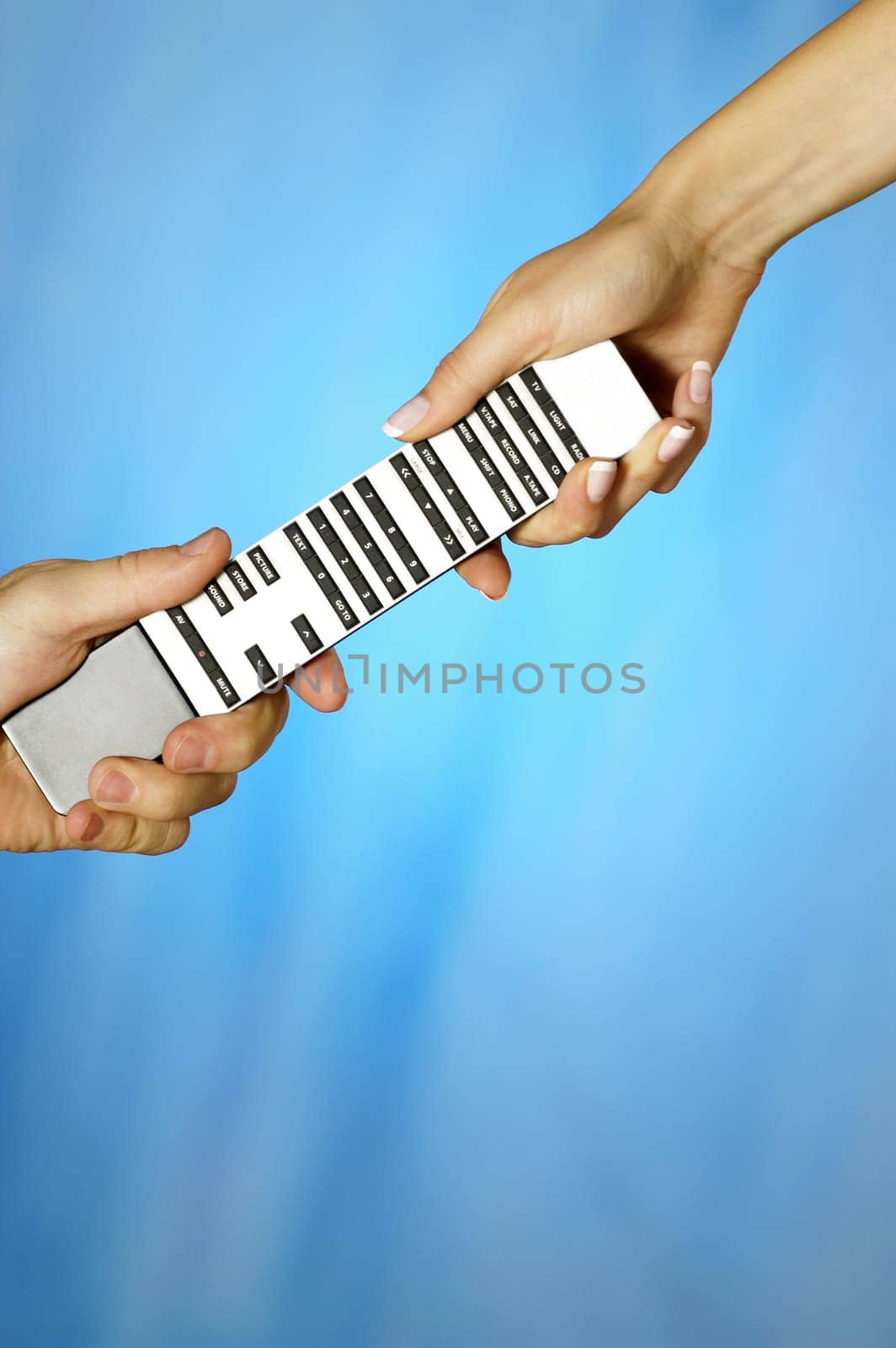 Close-up of a man and a womanŽs hands holding a remote control