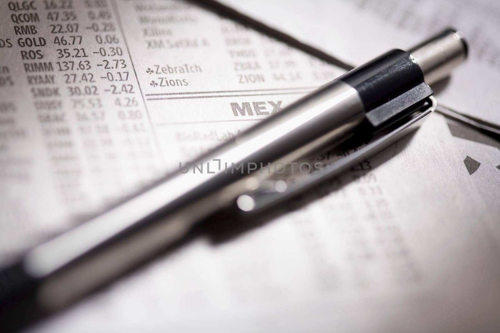 Close_up of a pen on financial newspapers