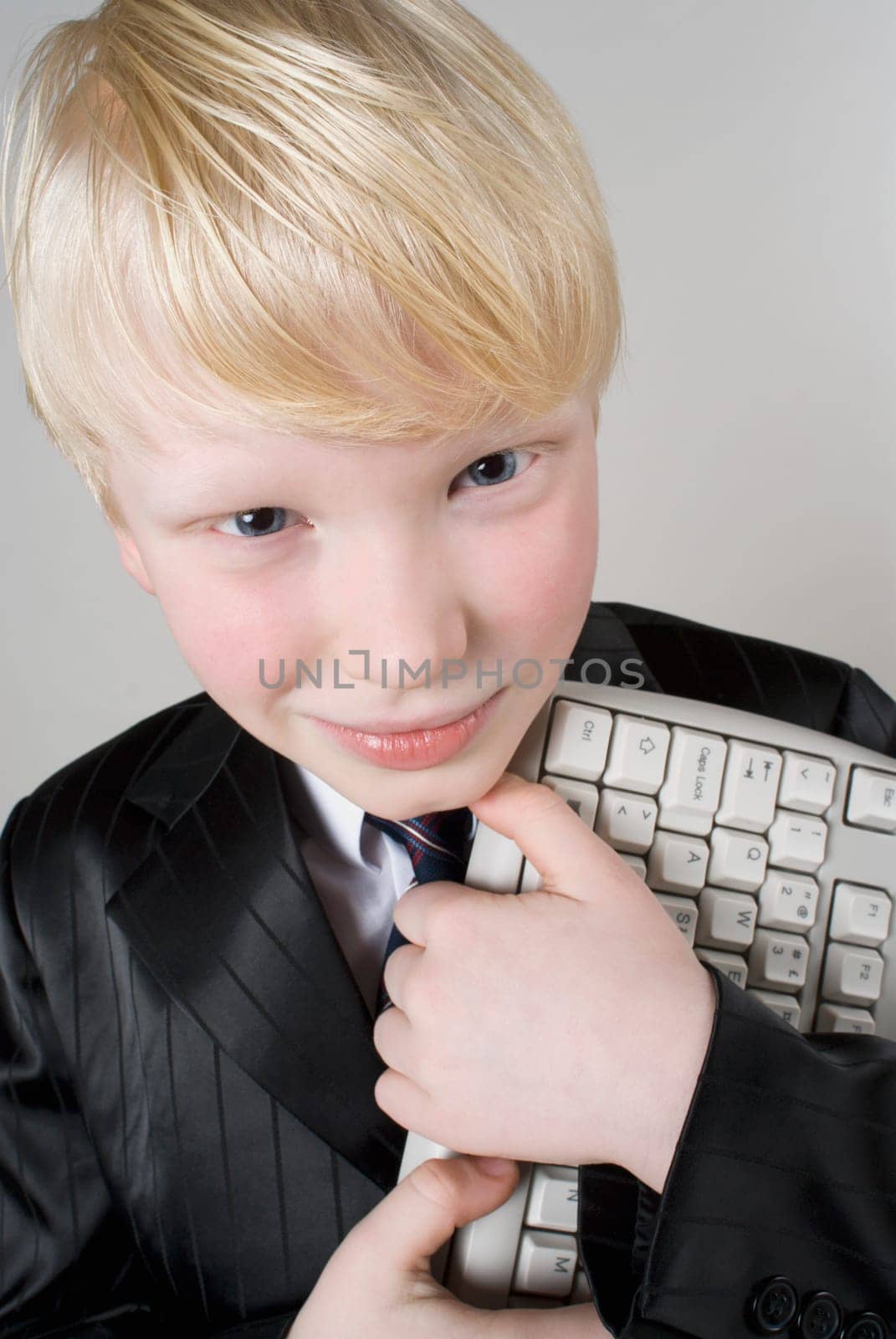 Close_up of a boy holding a computer keyboard