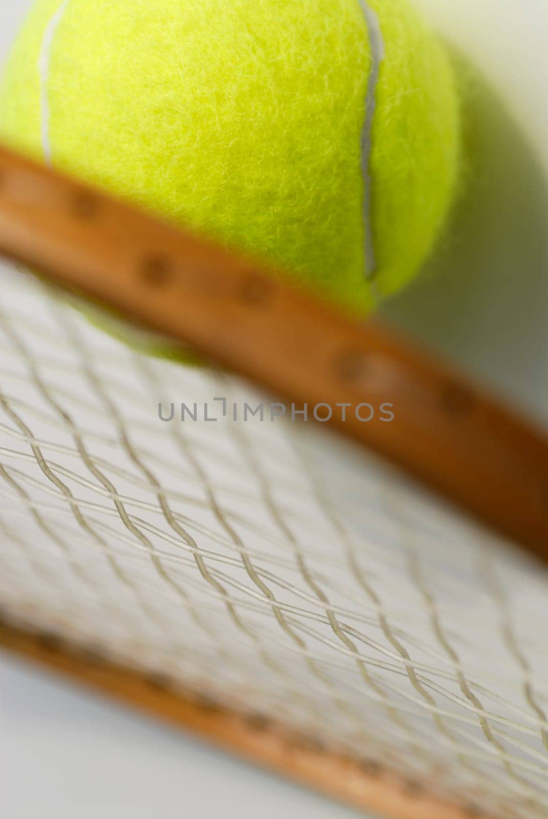 Close-up of a tennis ball with a tennis racket