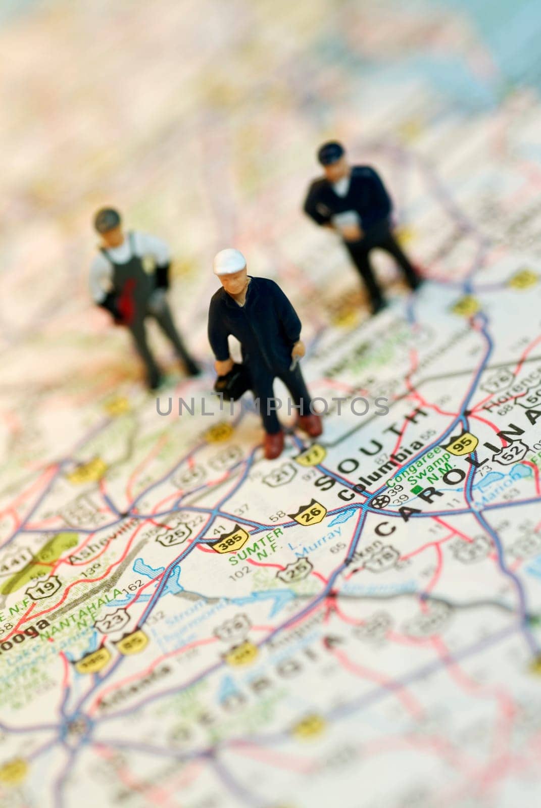 Close-up of the figurines of three construction workers on a map