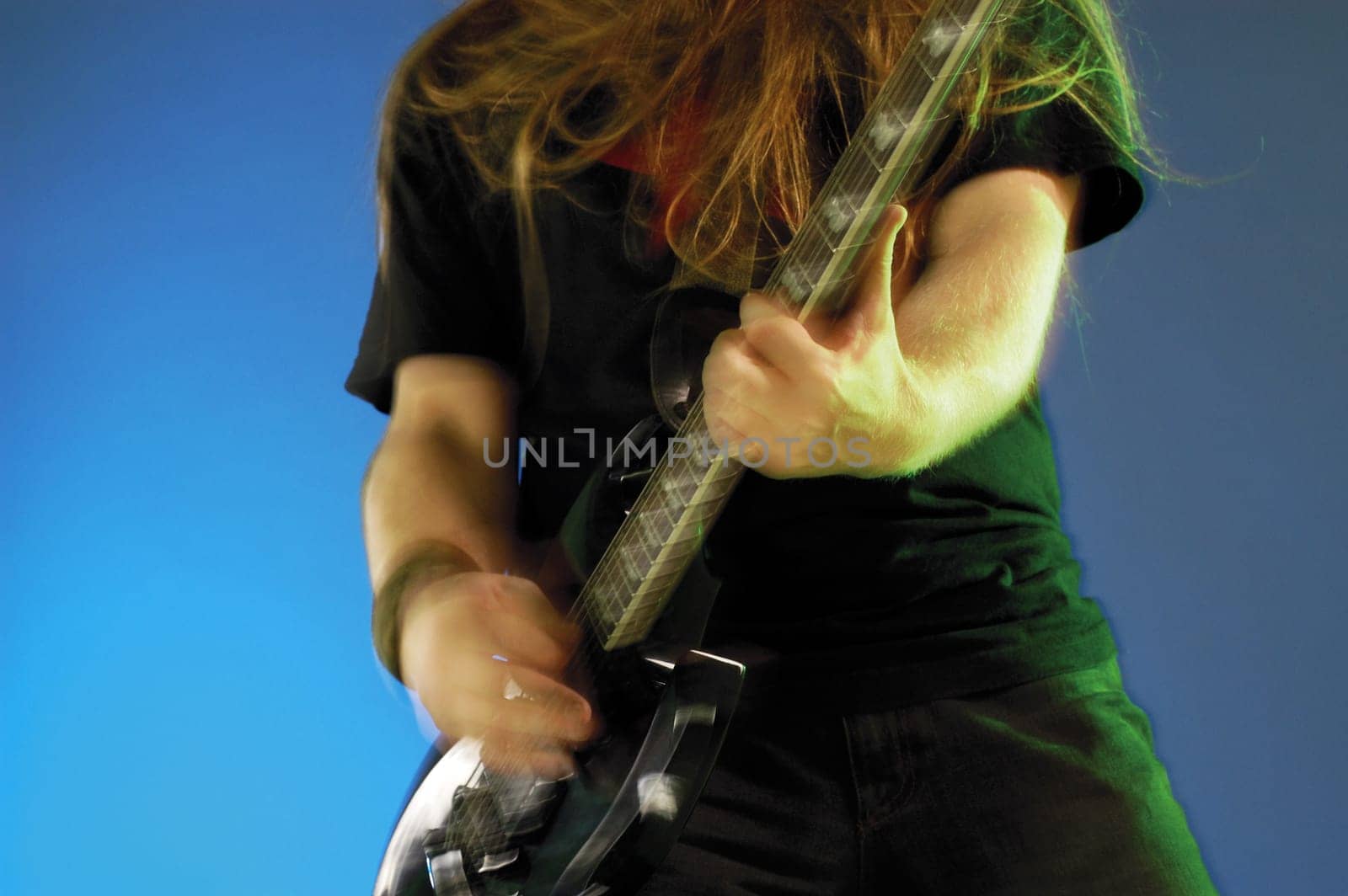 Mid section view of a musician playing the electric guitar