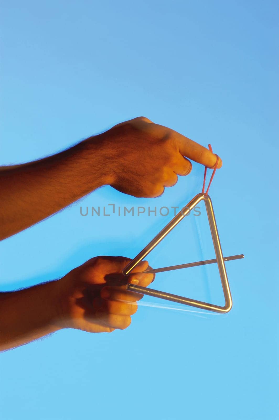 Close-up of a musicianŽs hands playing the triangle