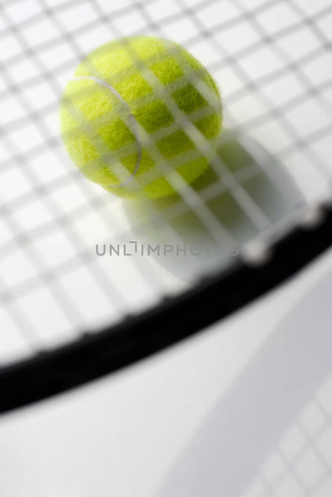 Close-up of a tennis racket on a tennis ball
