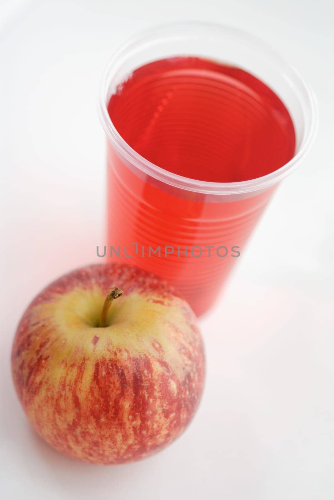 High angle view of an apple with a glass of juice