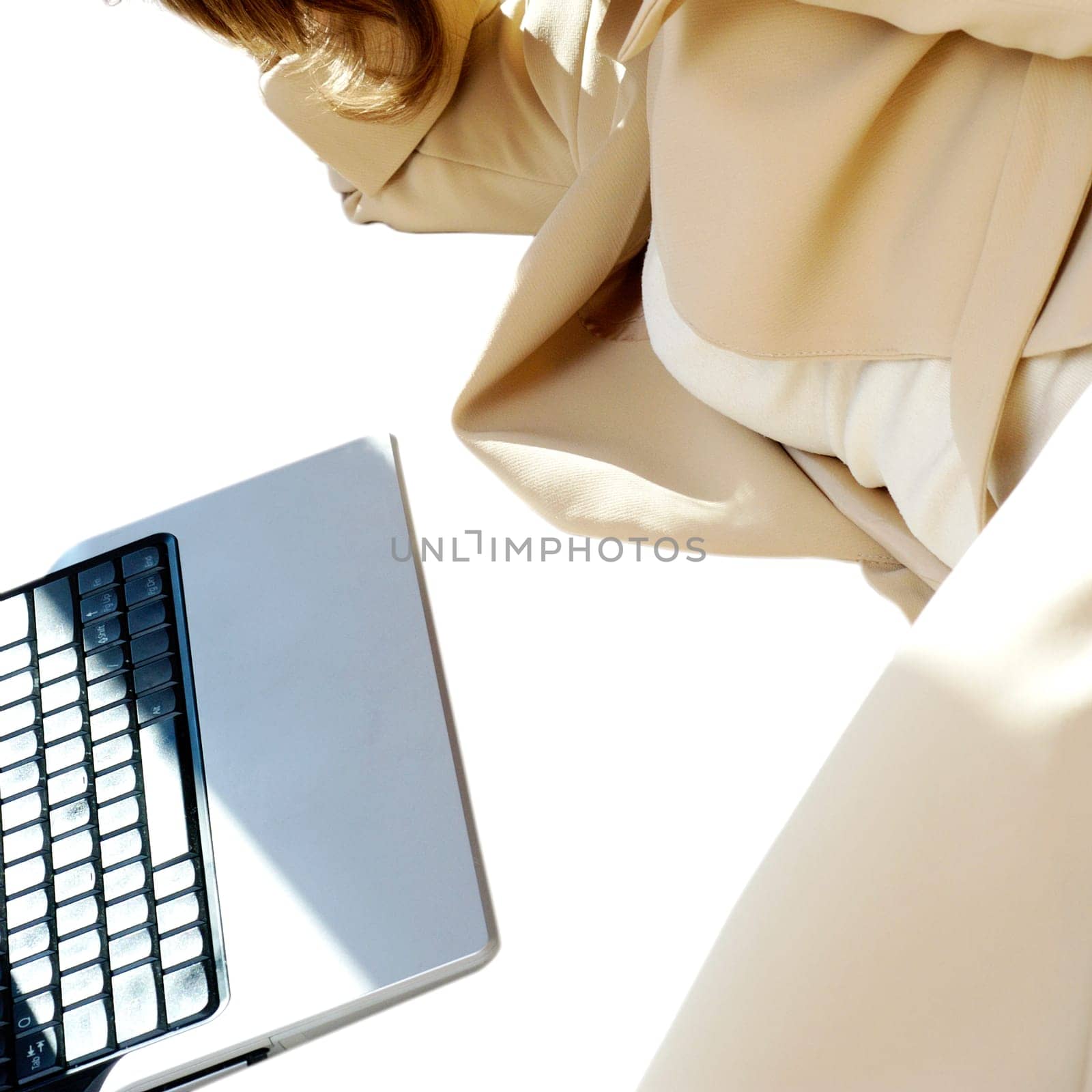 Mid section view of a businesswoman lying in front of a laptop