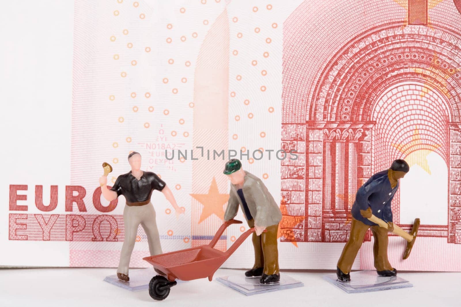 Figurines of manual workers in front of a European union euro note