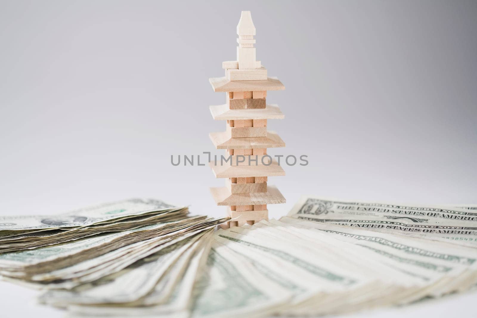 Miniature building with a pile of US paper currency