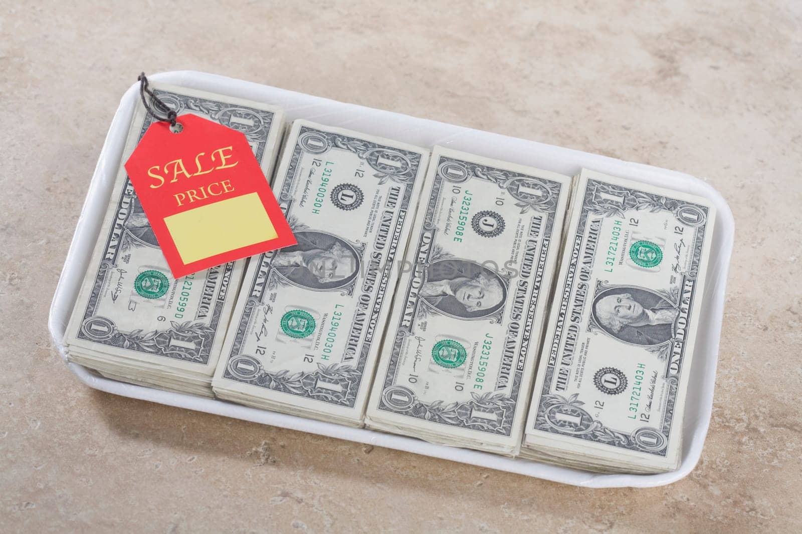 Close_up of a price tag on a container filled with US dollar bills