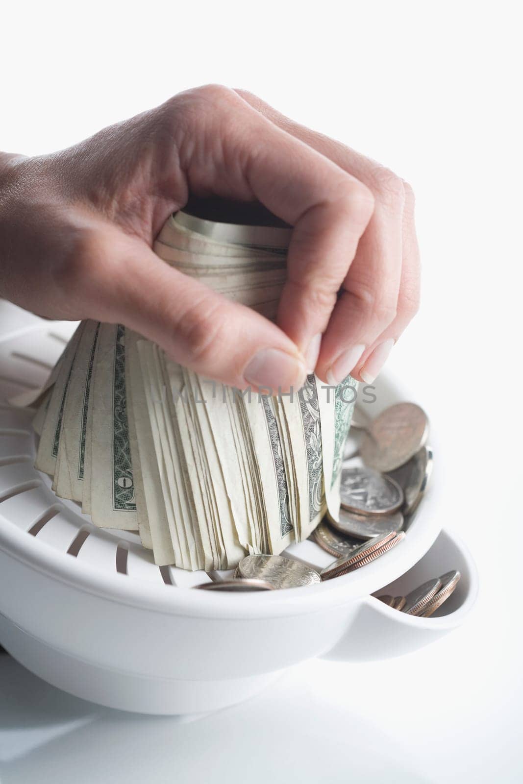 Close_up of personŽs hand squeezing US dollar bills in a juicer